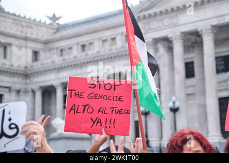Buenos Aires, Argentina, Feb 16, 2024: demonstration in solidarity with Palestine and against Israel attack and genocide. Palestinian flag and sign wi Stock Photo