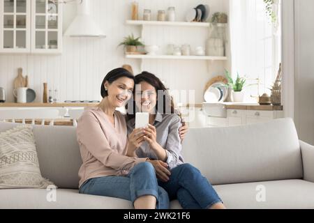 Happy mother and daughter using smart phone Stock Photo