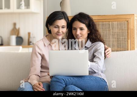 Pretty mature woman and grownup daughter using laptop Stock Photo