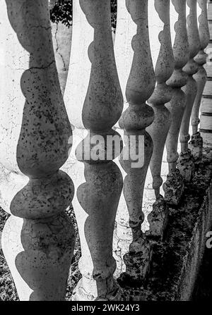 Monochrome Majesty: Sunlit Concrete Pillars. Black and white , colors. Pattern and texture . Part of the house fence. Stock Photo