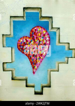 Graffiti mural of a heart inside a painted frame in a brick wall, in Shoreditch, East London Stock Photo