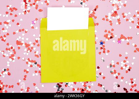 Wedding invitation card mockup, yellow envelope with heart confetti glitter on pink yellow. Blank card mockup Stock Photo