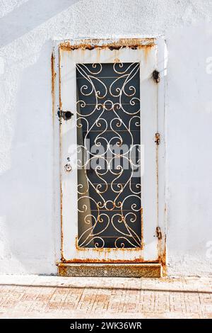 front view closeup of vintage metal door with wood texture and metallic handle Stock Photo