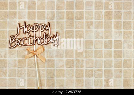 happy birthday text concept with ribbon isolated on tiles background Stock Photo