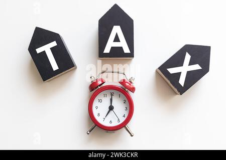 Tax text in wooden cubes and tax or vat form documents to complete Individual income tax return form for payment to Government. Calculation tax return Stock Photo