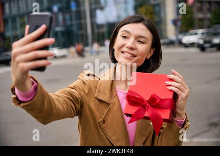 Smiling pretty female very excited receiving present Stock Photo