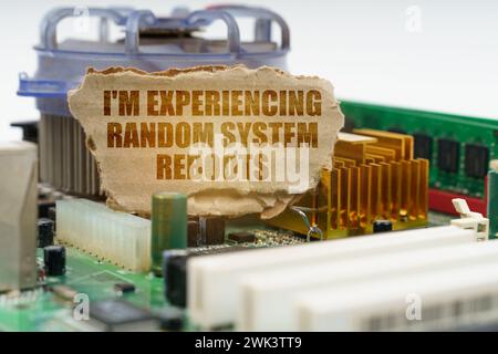 On the computer motherboard there is a cardboard with the inscription - I'm experiencing random system reboots. Computer repair concept. Stock Photo