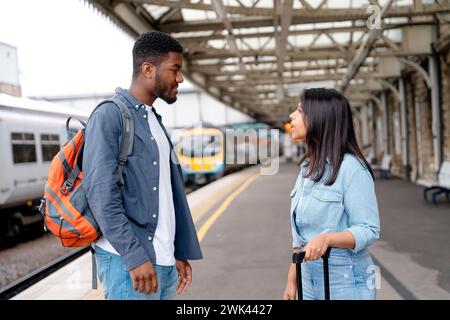 a young couple swearing and argueing with each othe  at the train station on the platform  The concept of disagreements in the family Stock Photo