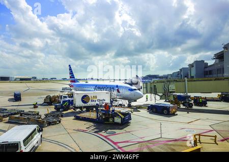 View of an American Airlines plane at Miami Airport, connected to the boarding ramp for passenger boarding. Miami. USA. Stock Photo