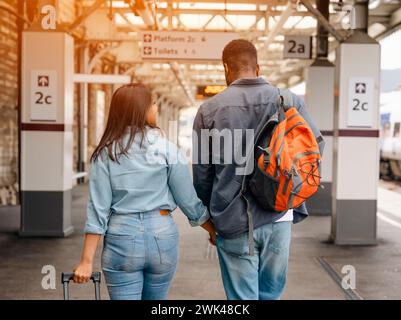 Happy couple embracing on railway station platform. Meeting, saying goodbye the spouse, friends. Travel lifestyle concept Stock Photo