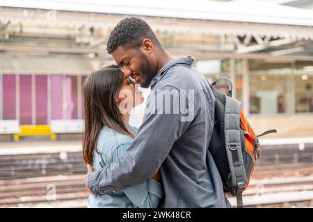 Happy couple embracing on railway station platform. Meeting, saying goodbye the spouse, friends. Travel lifestyle concept Stock Photo