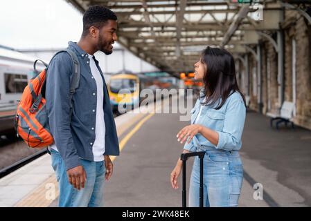 a young couple swearing and argueing with each othe at the train station on the platform The concept of disagreements in the family Stock Photo