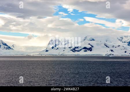 Mountains on land and icebergs floating in Antarctica. Stock Photo