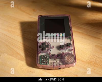 Miami, Florida, United States - November 26, 2023: Vintage Nintendo Game Boy Color handheld console color model Atomic Purple on a table. Stock Photo