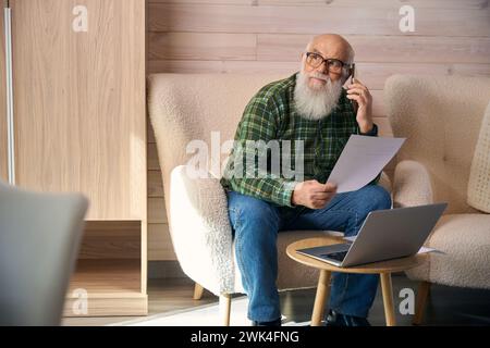 Elderly pensioner works with documents in the living room Stock Photo