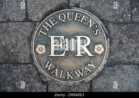 A metal plaque in the floor in Windsor Yards in Windsor, Berkshire UK bears a royal seal of Queen Elizabeth 2nd Stock Photo