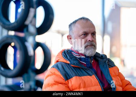 A man waiting at the garage for his car to be serviced and winter tires fitted ahead of winter season Stock Photo