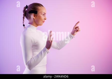 Young woman in smartglasses against colored background Stock Photo