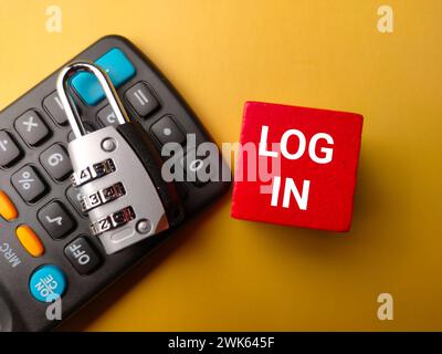 Top view padlock and calculator with text LOG IN on yellow background. Stock Photo