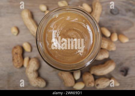 Tasty peanut nut paste in jar on table, top view Stock Photo