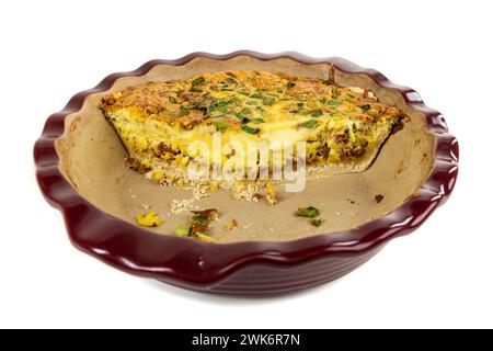 Leftovers of an egg and green onion quiche in a red ceramic baking dish Stock Photo