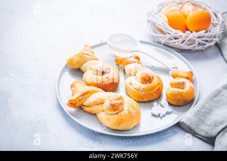 Buns made from yeast dough in a shape of Easter bunny and colored eggs Stock Photo