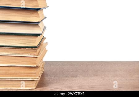 Stack of old books on wooden surface isolated on white background Stock Photo