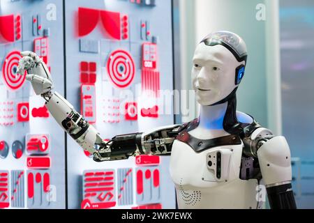 Advanced humanoid robot with a mechanical arm demonstrating artificial intelligence in a high-tech environment. Stock Photo