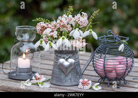 spring arrangement with bouquet of snowdrops and flowers of fragrant viburnum, quail eggs and table lantern Stock Photo