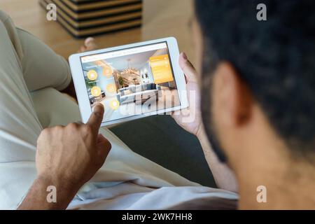 Man adjusting household functions, lighting, security cameras, door locks and thermostat or heating settings in smart home system. Stock Photo