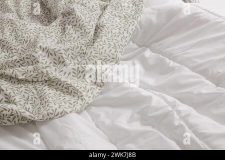 Messy bed. Cotton unmad blanket and sheets on bed Stock Photo