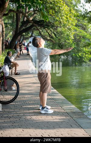 Man doing early morning exercises around Hoan Kiem Lake in Hanoi, Vietnam Stock Photo