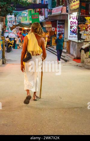 Sadhu at the street, Rishikesh. Wandering monk in India. Walking indian pilgrim. Getting away from it all. Travel concept. Spiritual man on street. Stock Photo
