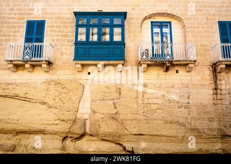 Traditional balconies and stonework on the side of a home in Malta Stock Photo