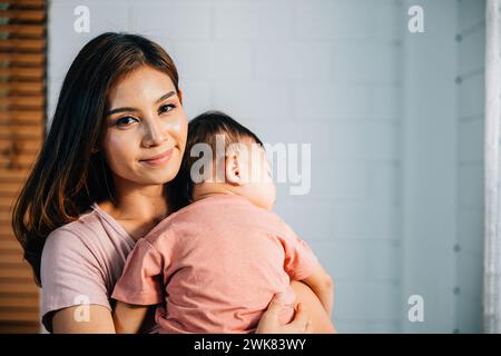 A tender loving biracial mother cradles her small sleeping newborn in her arms Stock Photo
