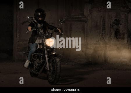 Biker Woman with Helmet and Leather Outfit In Dark Erea Stock Photo