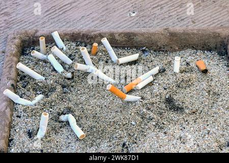 Cigarette stubs in a tray outside a restaurant Stock Photo