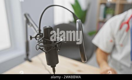 Blurred hispanic man with beard standing behind a studio microphone, suggesting a podcast or radio recording session. Stock Photo