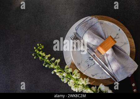 Easter table setting concept. Plate, easter eggs, cutlery and spring flower on dark background table Stock Photo