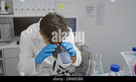 Young arab man scientist using microscope at laboratory Stock Photo