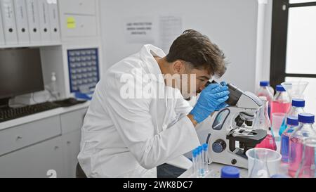 Young arab man scientist using microscope at laboratory Stock Photo