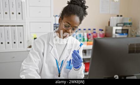 Focused african woman scientist analyzing sample in a laboratory setting Stock Photo