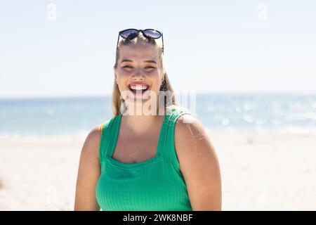Young plus size Caucasian woman smiles brightly at the beach Stock Photo