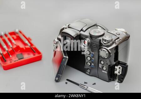 Disassembling of photo camera, close-up. Photographing equipment maintenance and repair. Hobby, occupation, business Stock Photo
