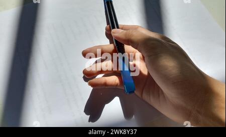 Photo of Asian holding a marker against a paper background Stock Photo
