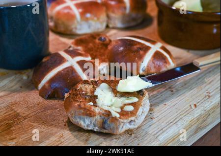 Toasted Hot Cross Buns with butter a traditional breakfast food eaten at Easter Stock Photo