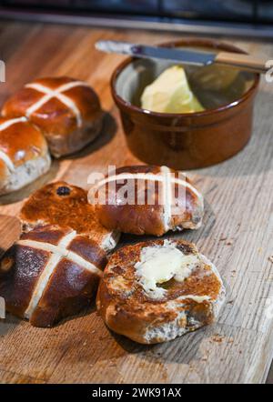 Toasted Hot Cross Buns with butter a traditional breakfast food eaten at Easter Stock Photo