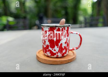 Indonesian herbal drink wedang uwuh served in a stainless cup with forest background Stock Photo
