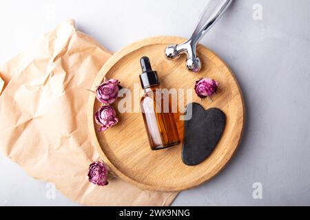 Serene beauty setting with gua sha, facial roller and essential oil for spa at home. Stock Photo