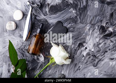 Minimalist skincare setup with massage roller, serum, gua sha on fluid art background. Stock Photo